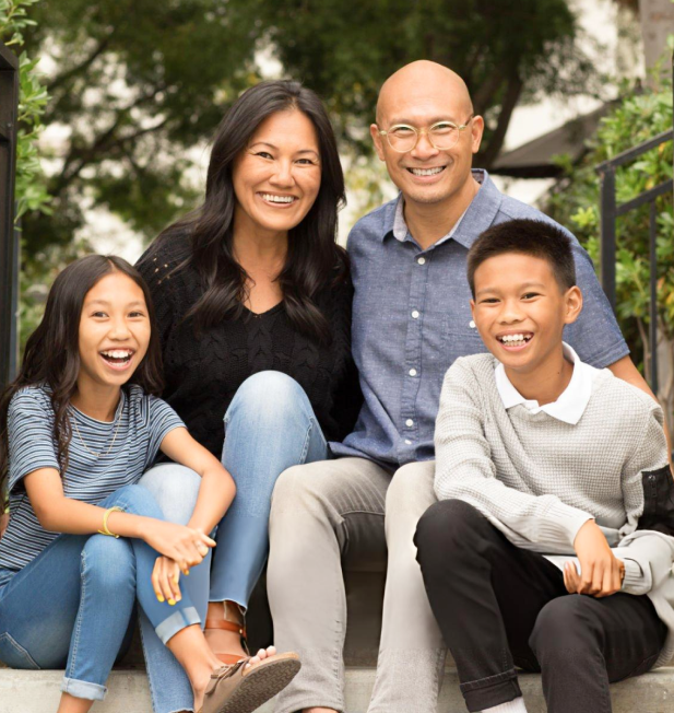 A family is posing for a picture while sitting on a set of stairs.