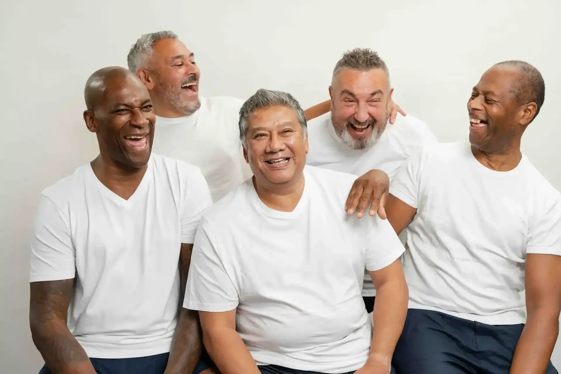 A group of men are sitting next to each other and laughing.