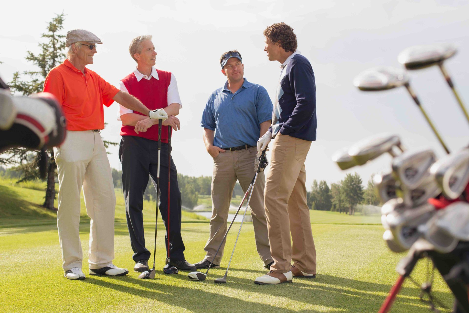 four men talking while golfing