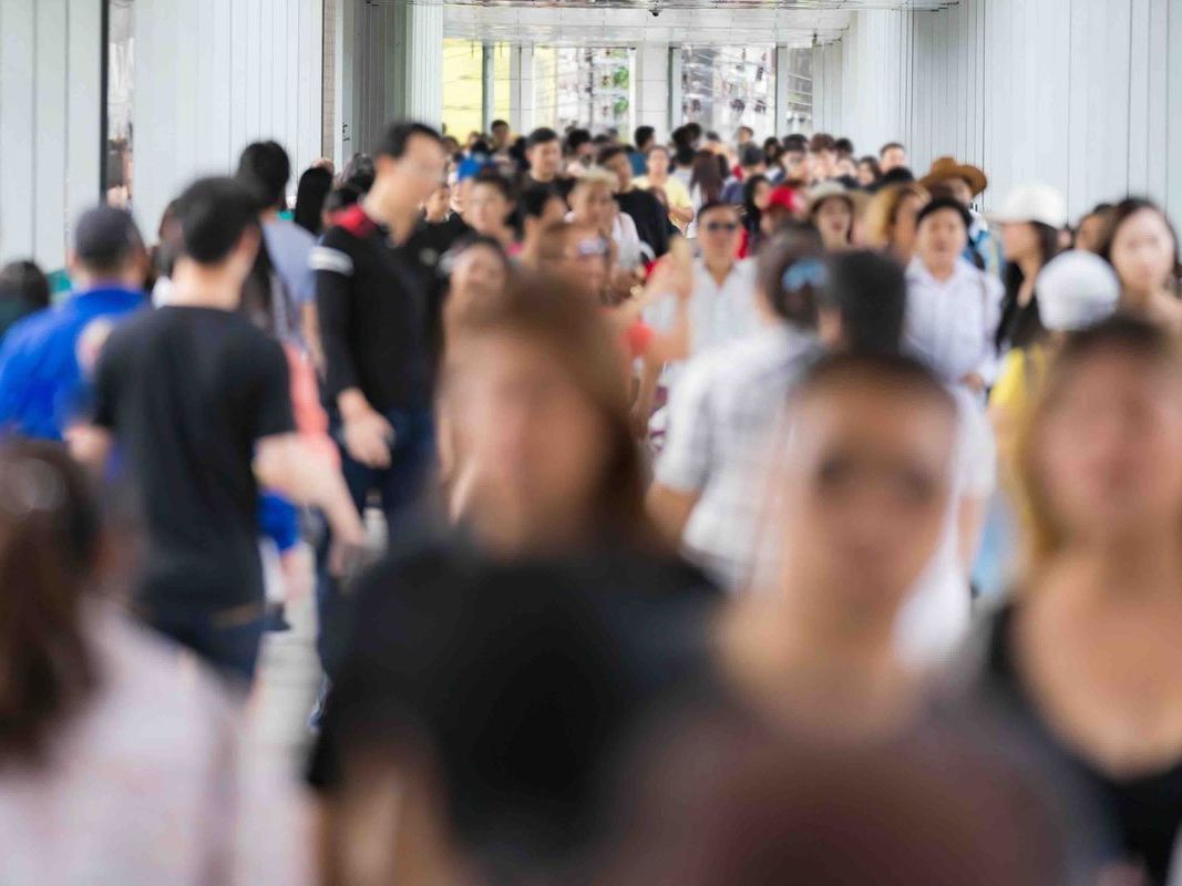 A blurry picture of a crowd of people walking down a street.