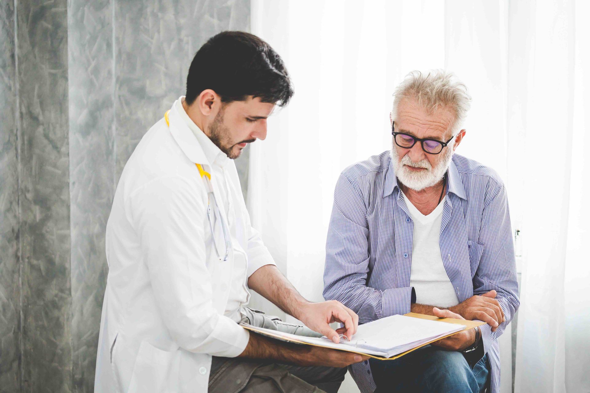 a doctor going over charts with an older male patient