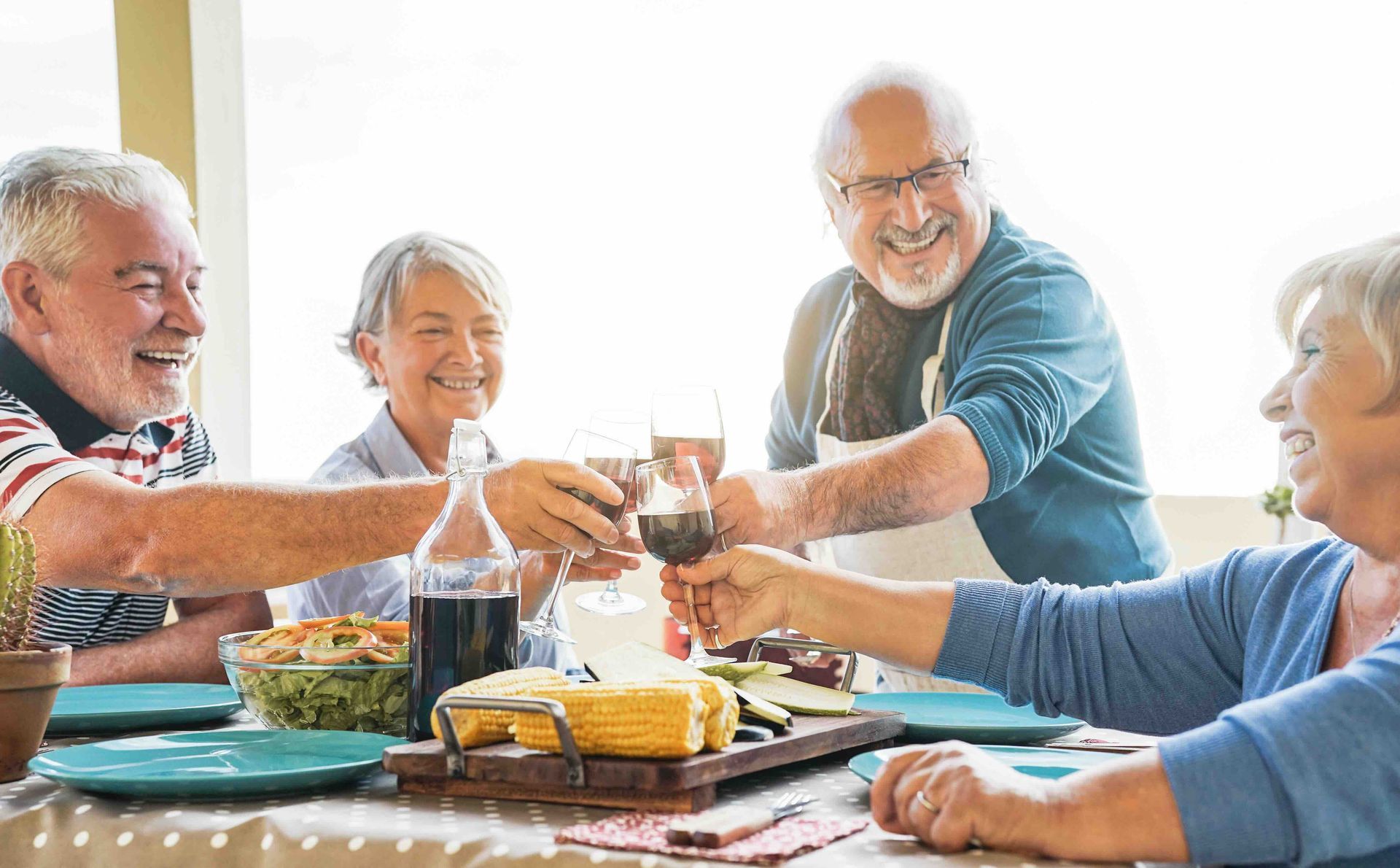 a group of elderly people toasting with wine glasses