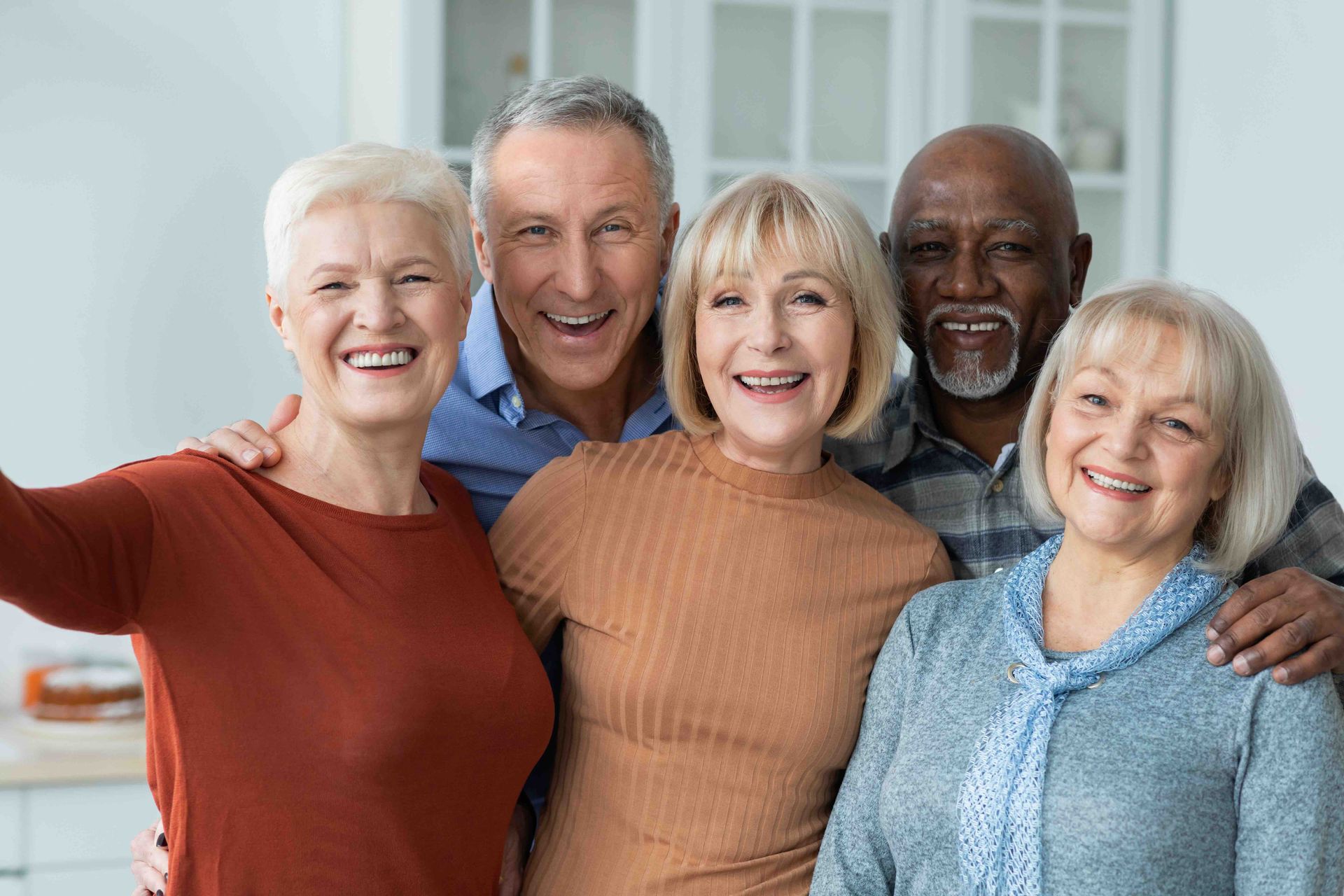 A group of older people are posing for a picture together and smiling.