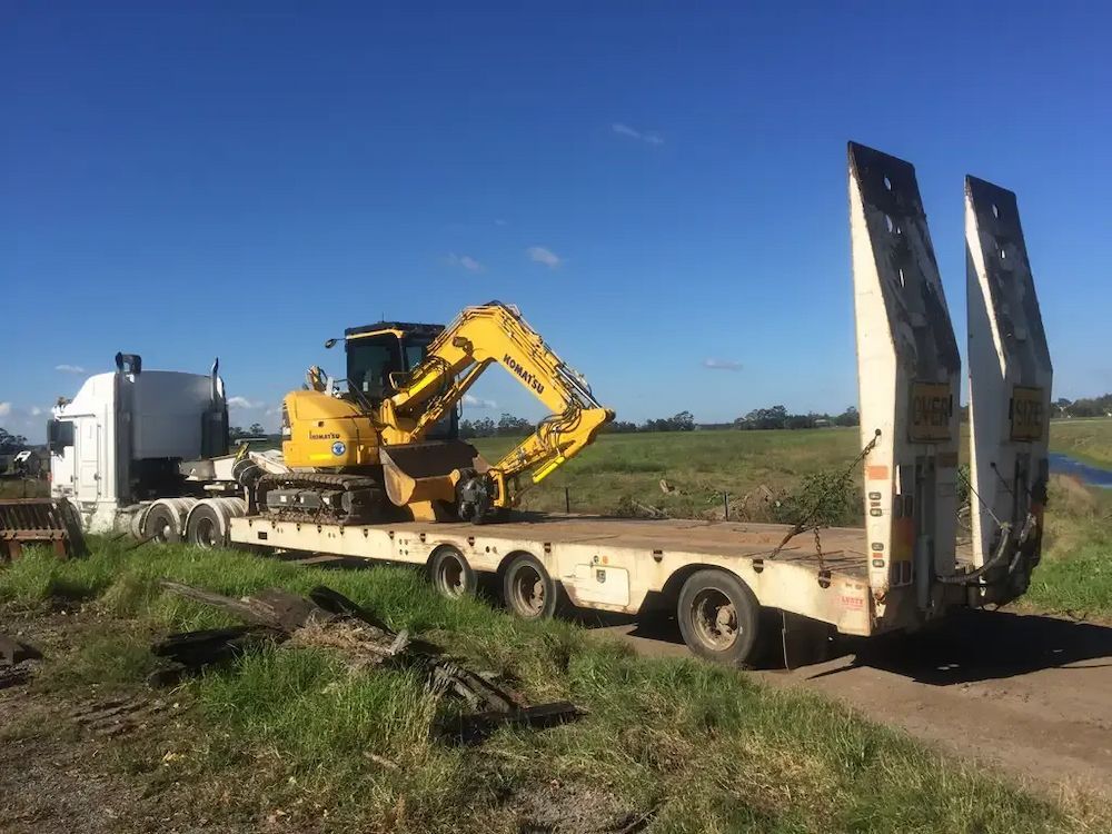 A Yellow Excavator is on a Flatbed Trailer — Lantry Earthmoving in Phoenix Park, NSW