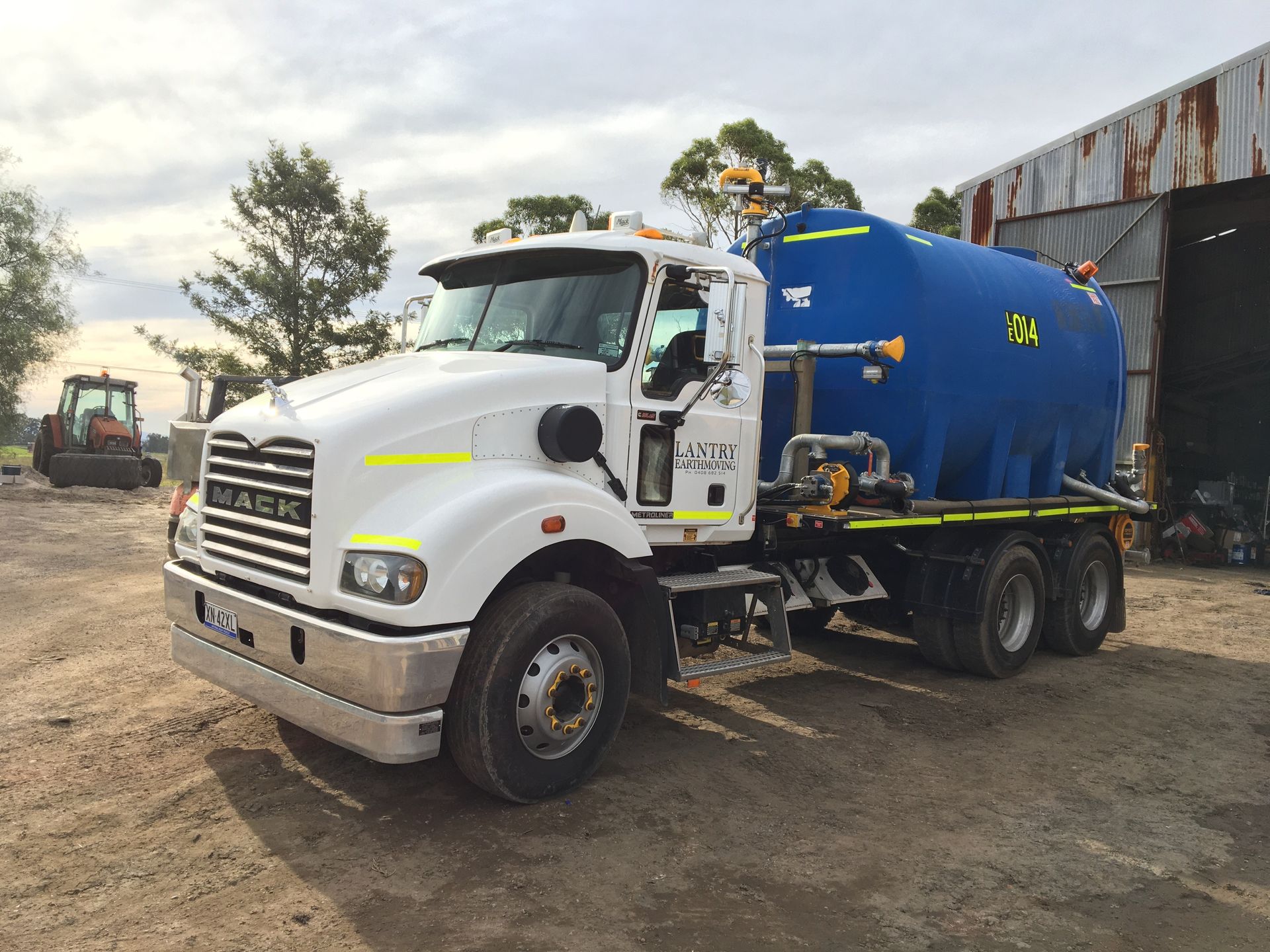 A White Truck is Driving Down a Dirt Road — Lantry Earthmoving in Phoenix Park, NSW