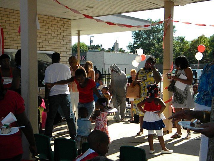 A group of people are gathered outside a building with balloons and a sign that says ix