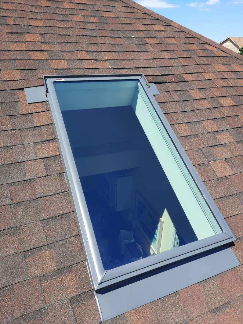 There is a skylight on the roof of a house.