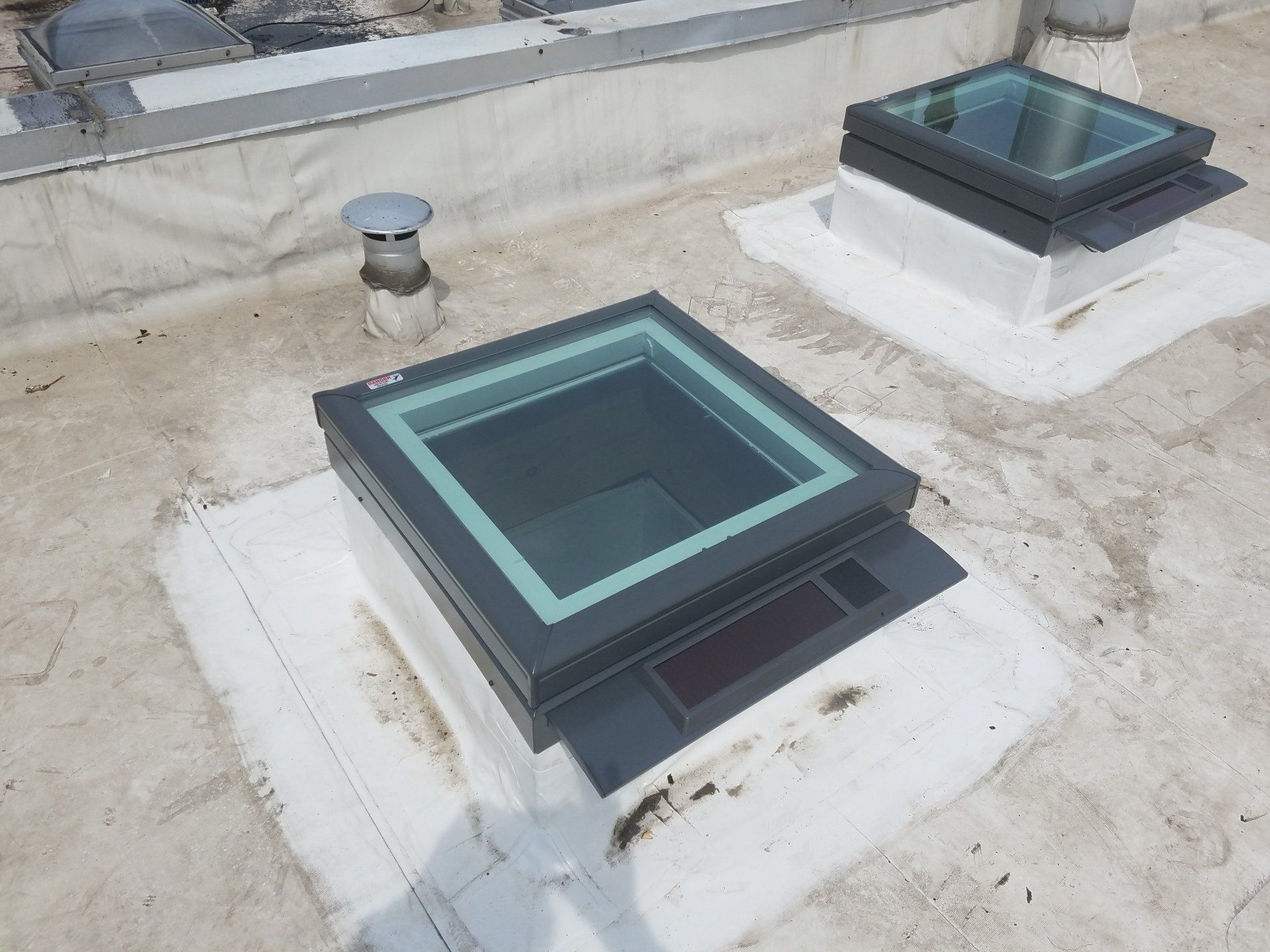 A roof with two square skylights on it