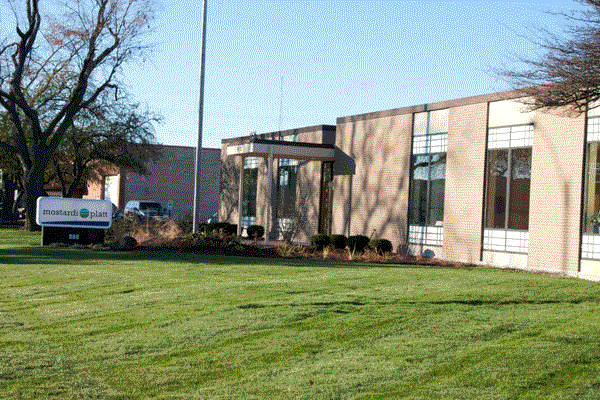 A Mostardi Platt Sign in Front of the lawn of a Building
