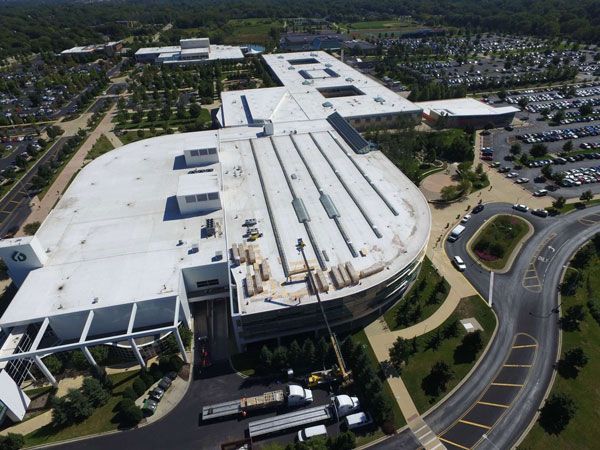 An Aerial View of a Large Building with a White Roof
