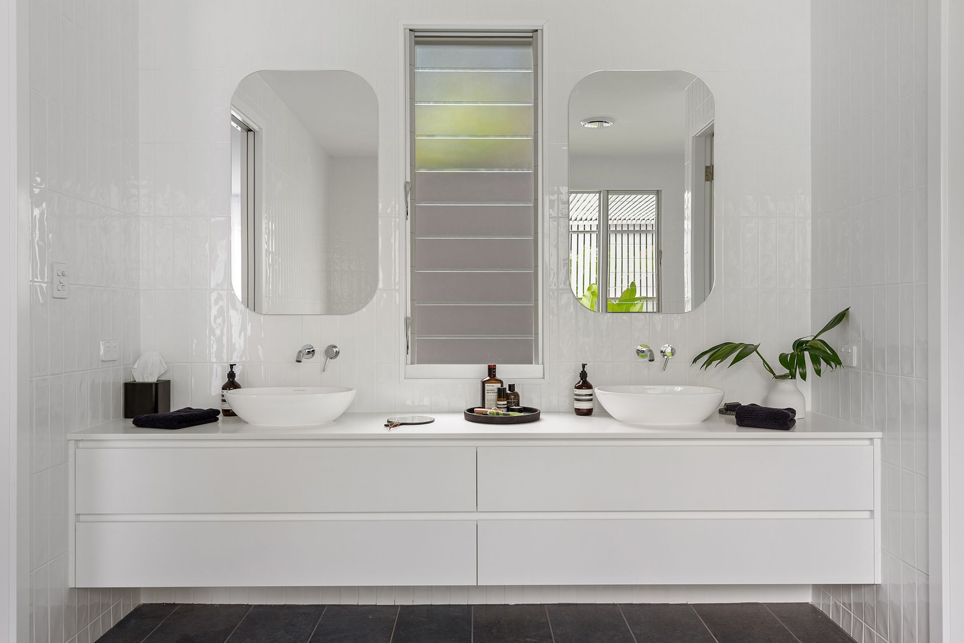 A bathroom with two sinks and two mirrors.