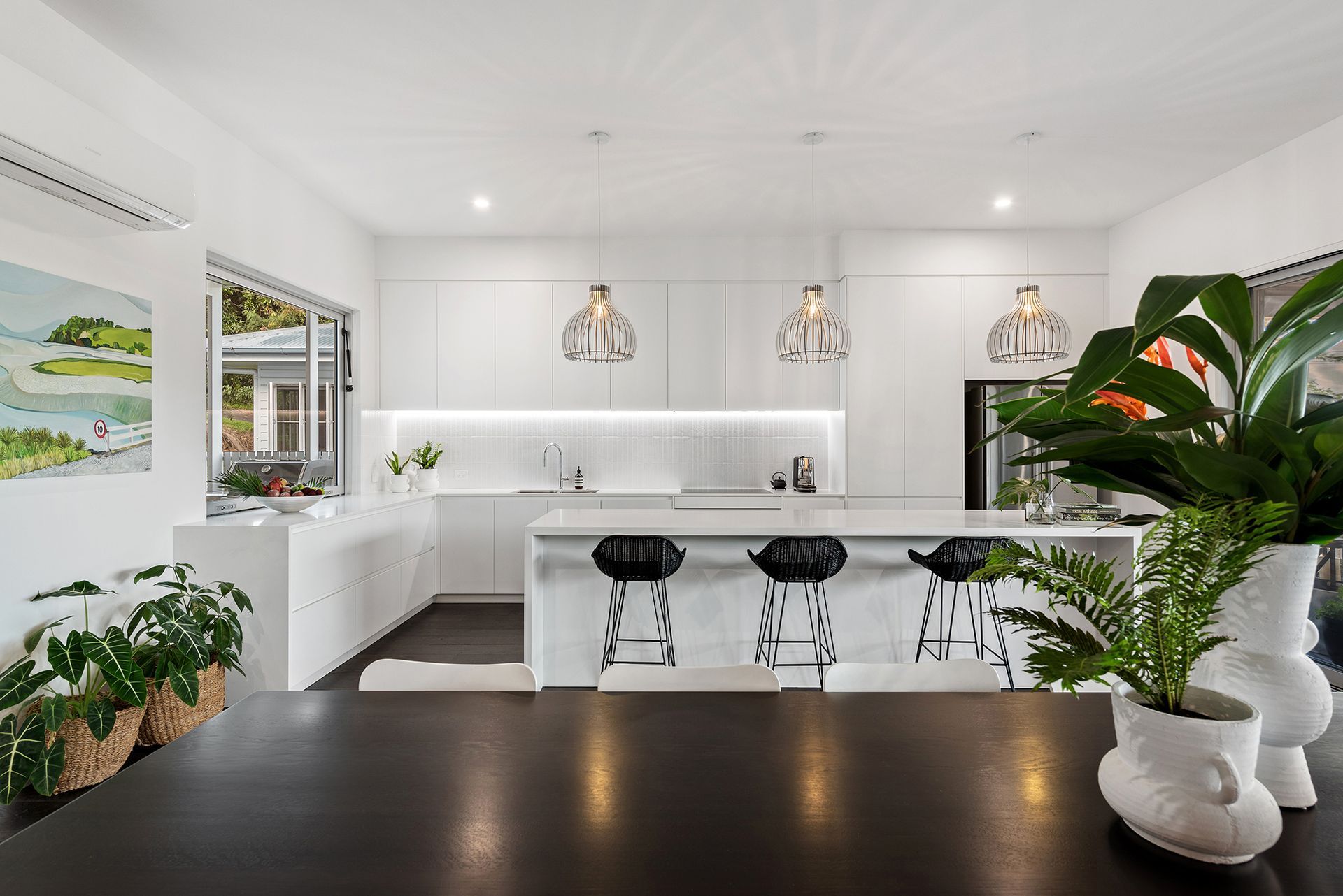 A kitchen with white cabinets and a large island in the middle of the room.