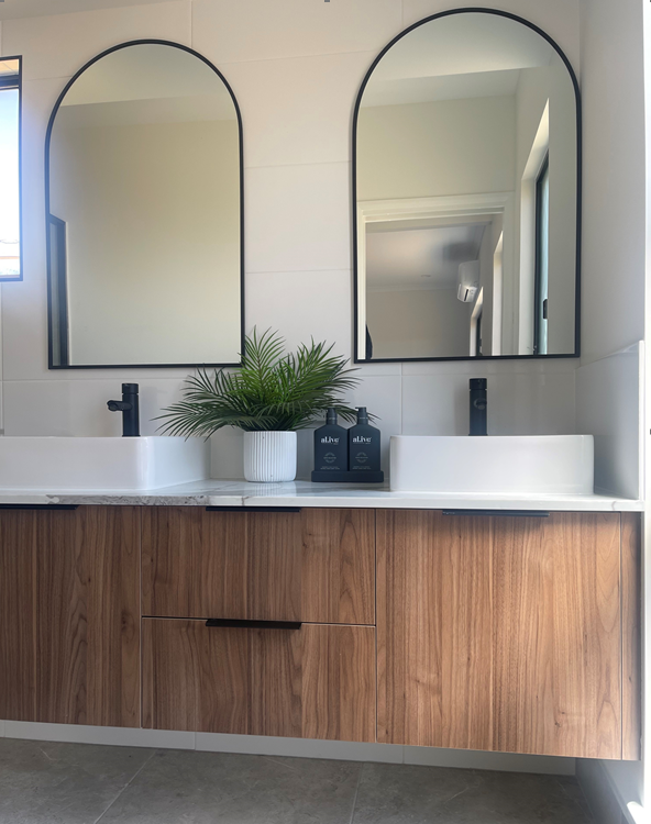 A bathroom with two sinks and two mirrors.