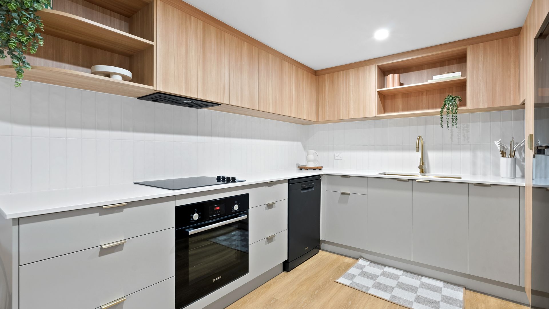 A kitchen with white cabinets , black appliances , a sink , and a stove.