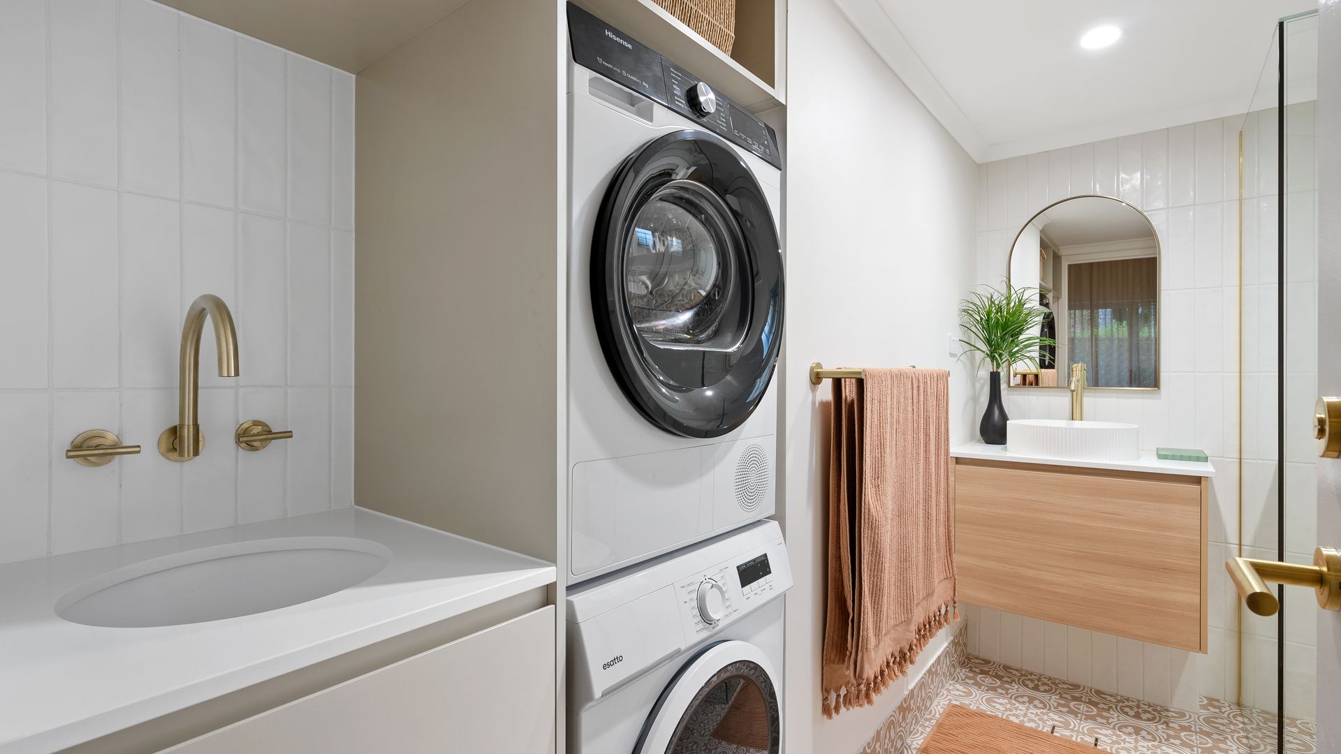 A bathroom with a washer and dryer stacked on top of each other.