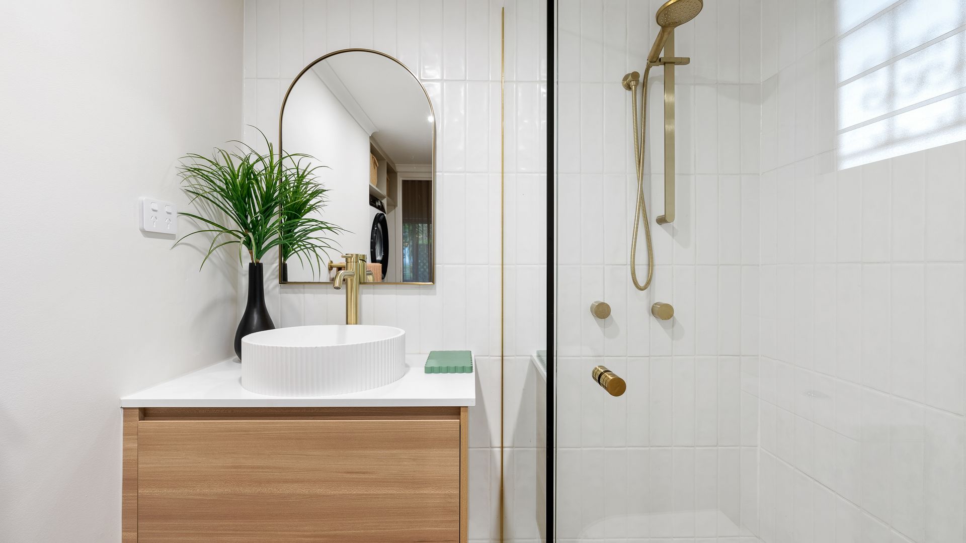 A bathroom with a sink , mirror , toilet and shower.