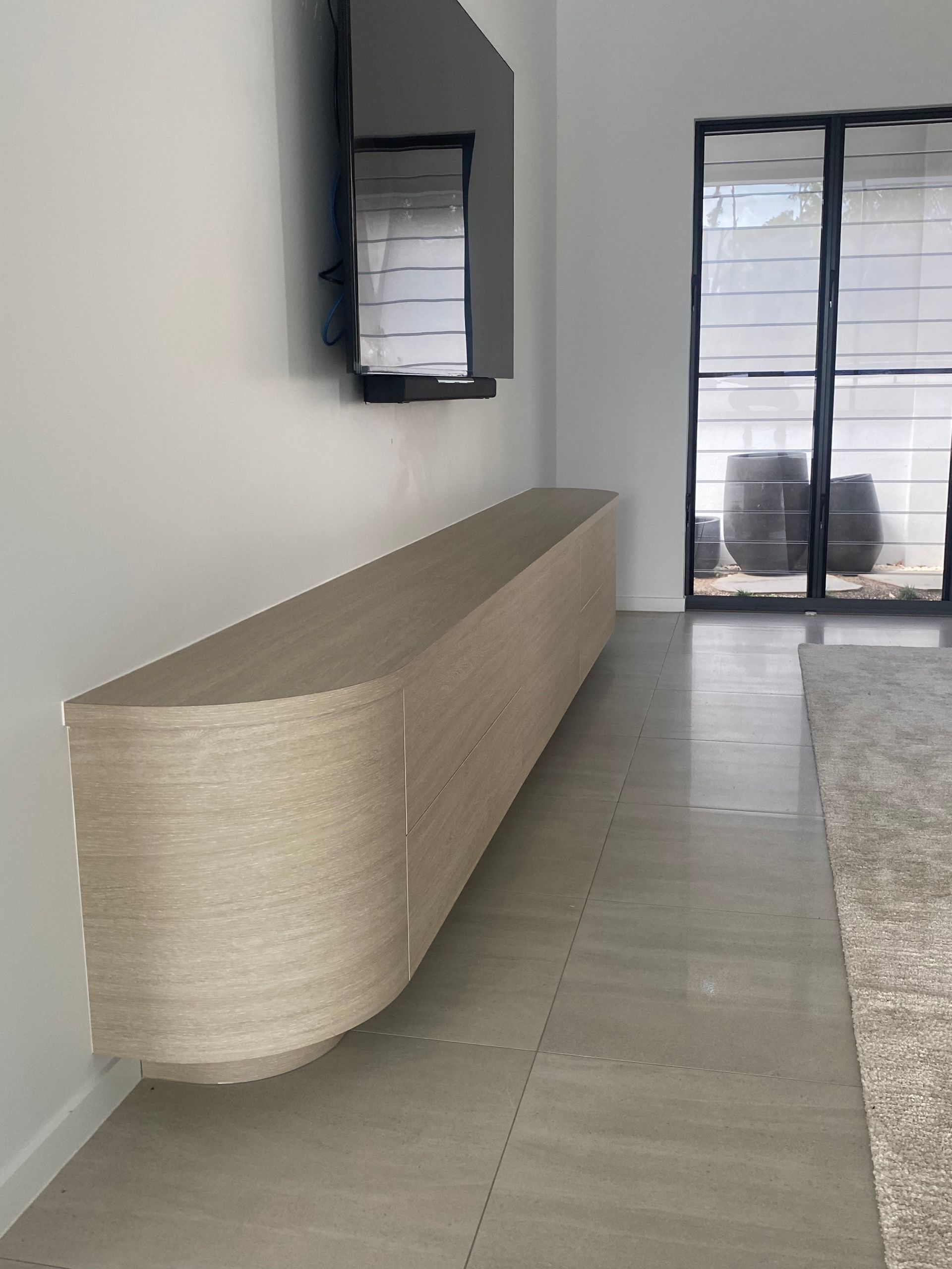 A living room with a flat screen tv mounted to the wall