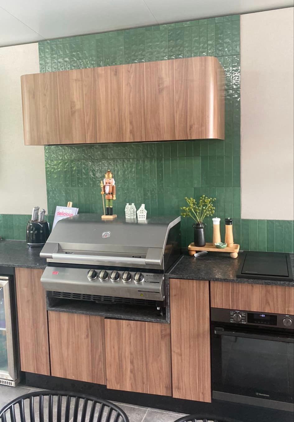 A kitchen with wooden cabinets and a grill on the counter.