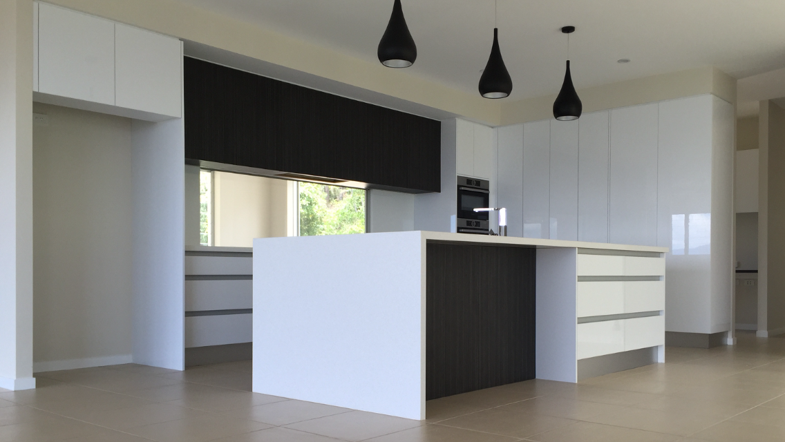 A kitchen with black and white cabinets and a large island