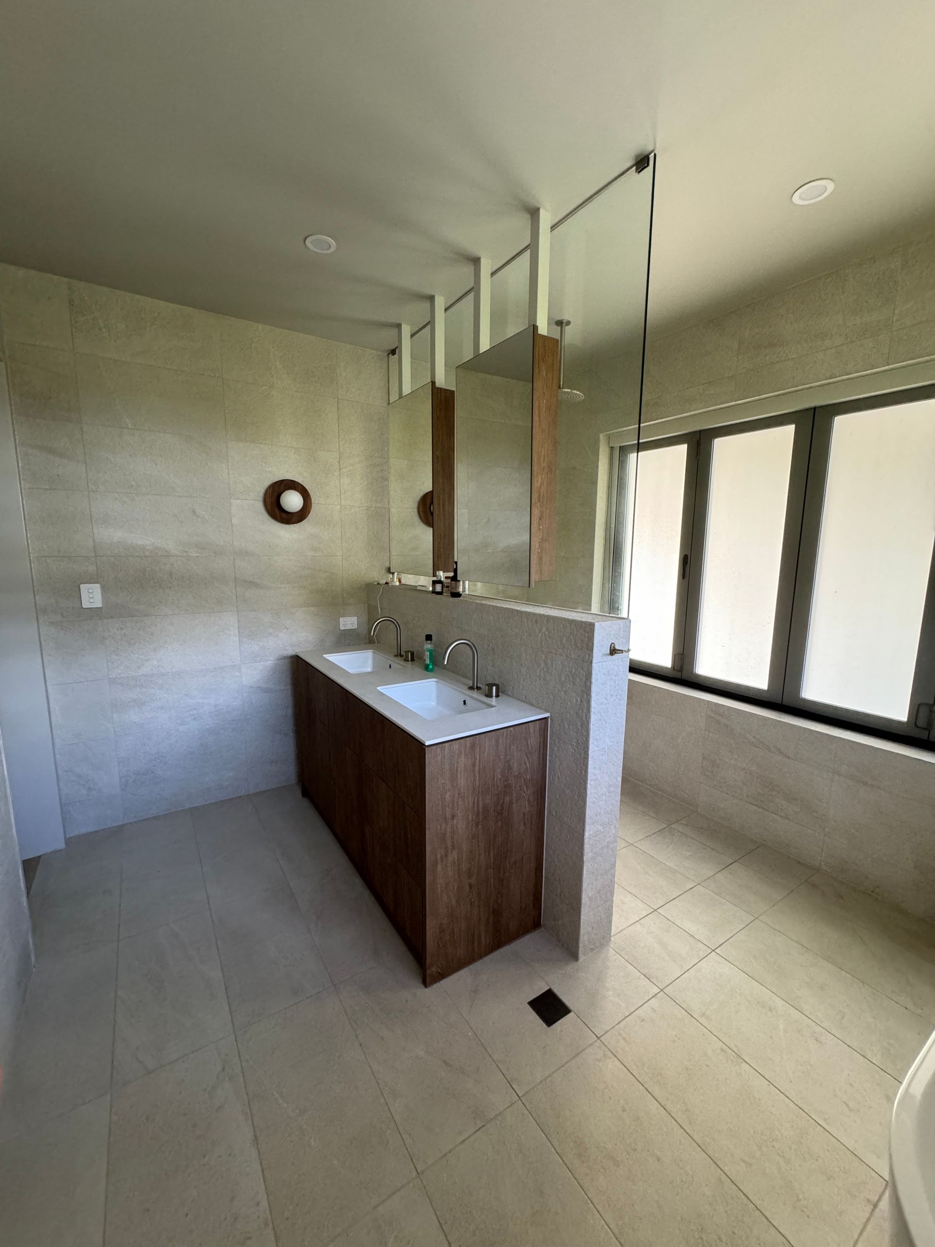 A bathroom with two sinks , a mirror and a tub.