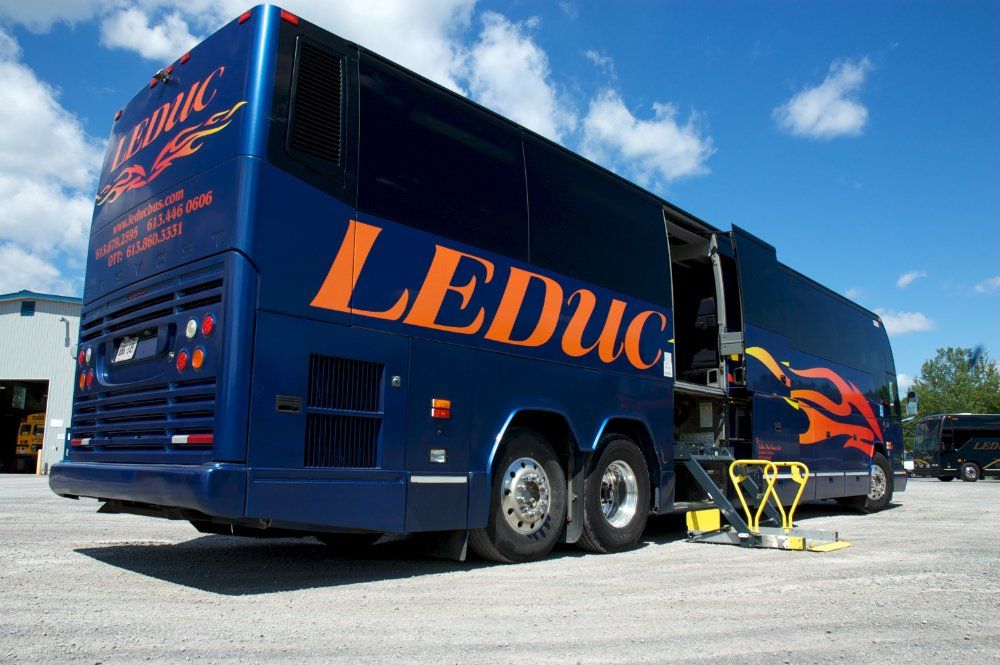 A blue leduc bus is parked in a parking lot