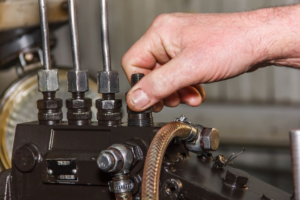 A Person is Working on a Machine With a Wrench — Mick Dunn Motor Repairs in Mackay, QLD