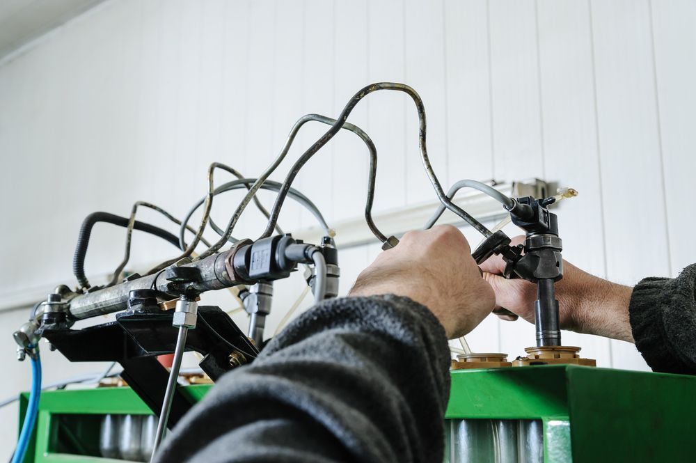 A Man is Working on a Machine in a Garage — Mick Dunn Motor Repairs in Mackay, QLD