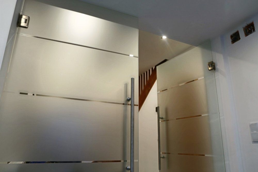 A glass door with a staircase in the background — Glass Pool Fencing Australia in Forster, NSW