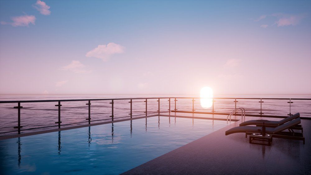 A Swimming Pool with A View of The Ocean at Sunset — Glass Pool Fencing Australia in Hallidays Point, NSW