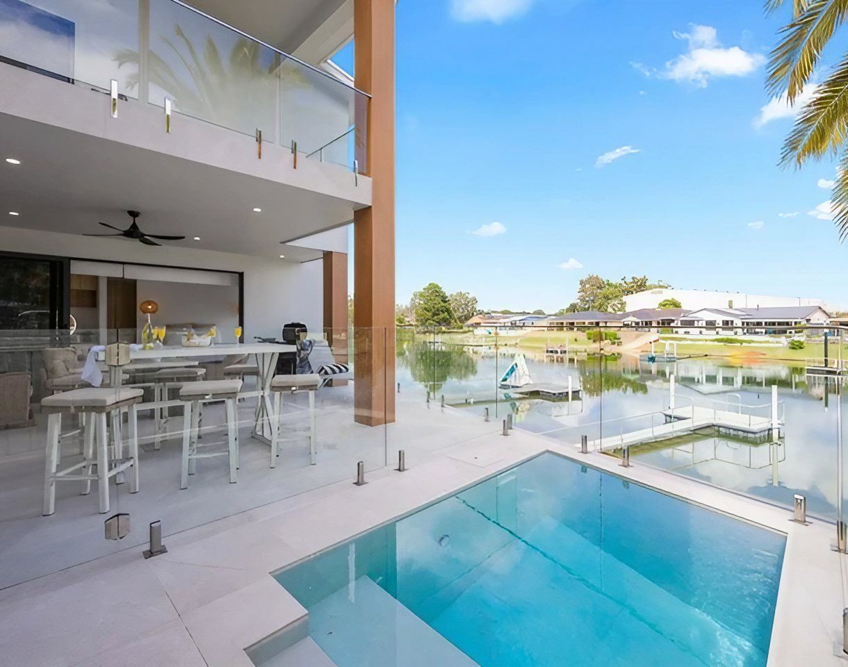 There Is a Large Swimming Pool in The Backyard of A House — Glass Pool Fencing Australia in Sydney, NSW