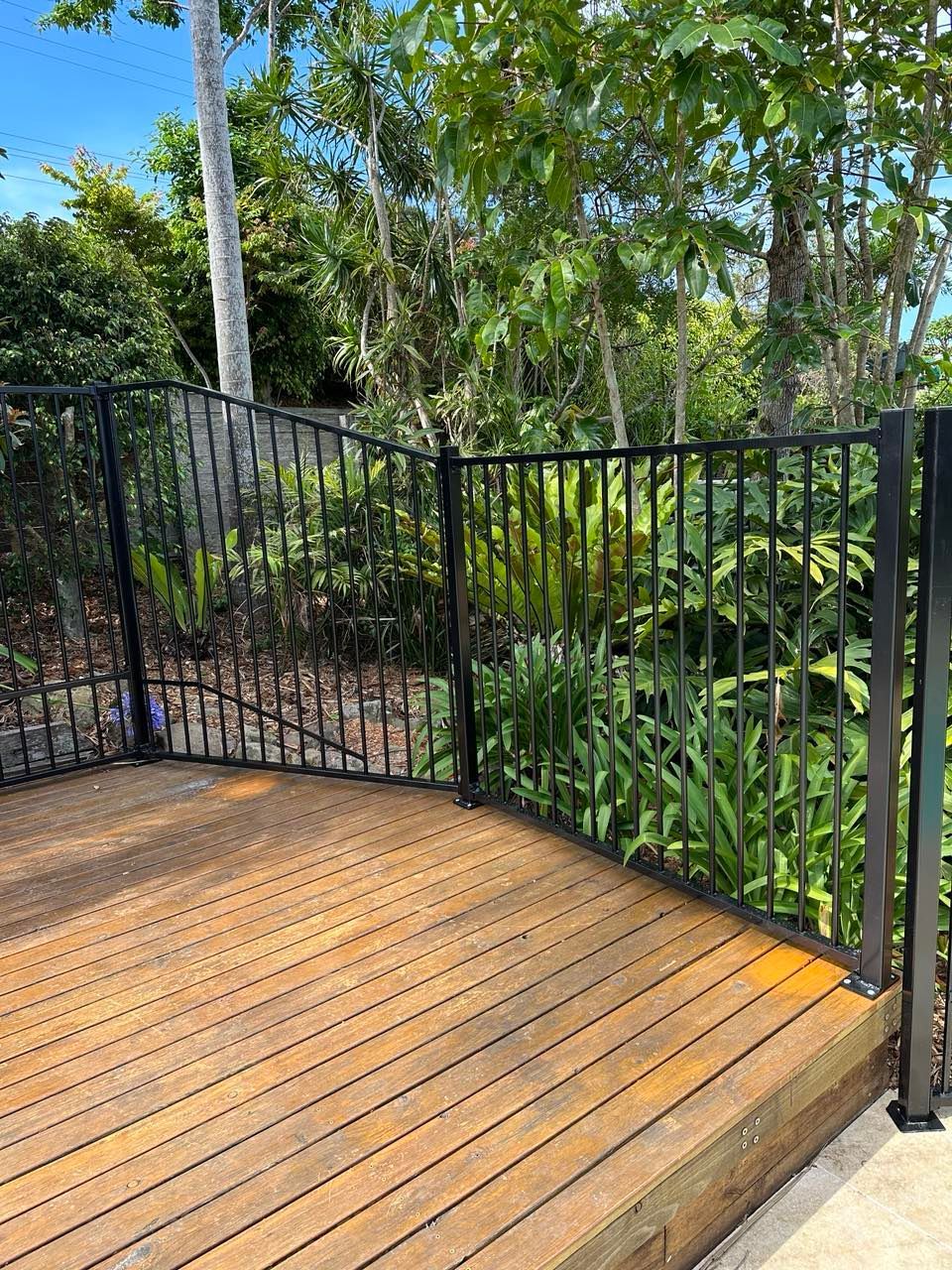 A Wrought Iron Fence Surrounds a Swimming Pool in A Backyard — Glass Pool Fencing Australia in Old Bar, NSW