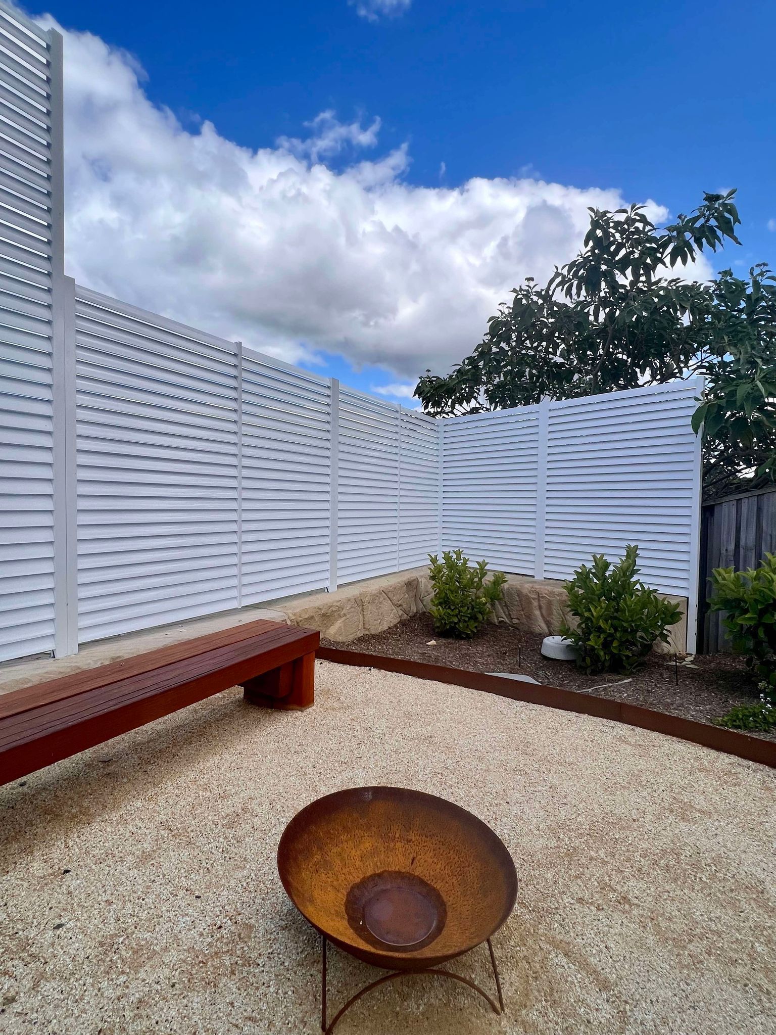 There is a fire pit in the middle of the yard.— Glass Pool Fencing Australia in Old Bar, NSW