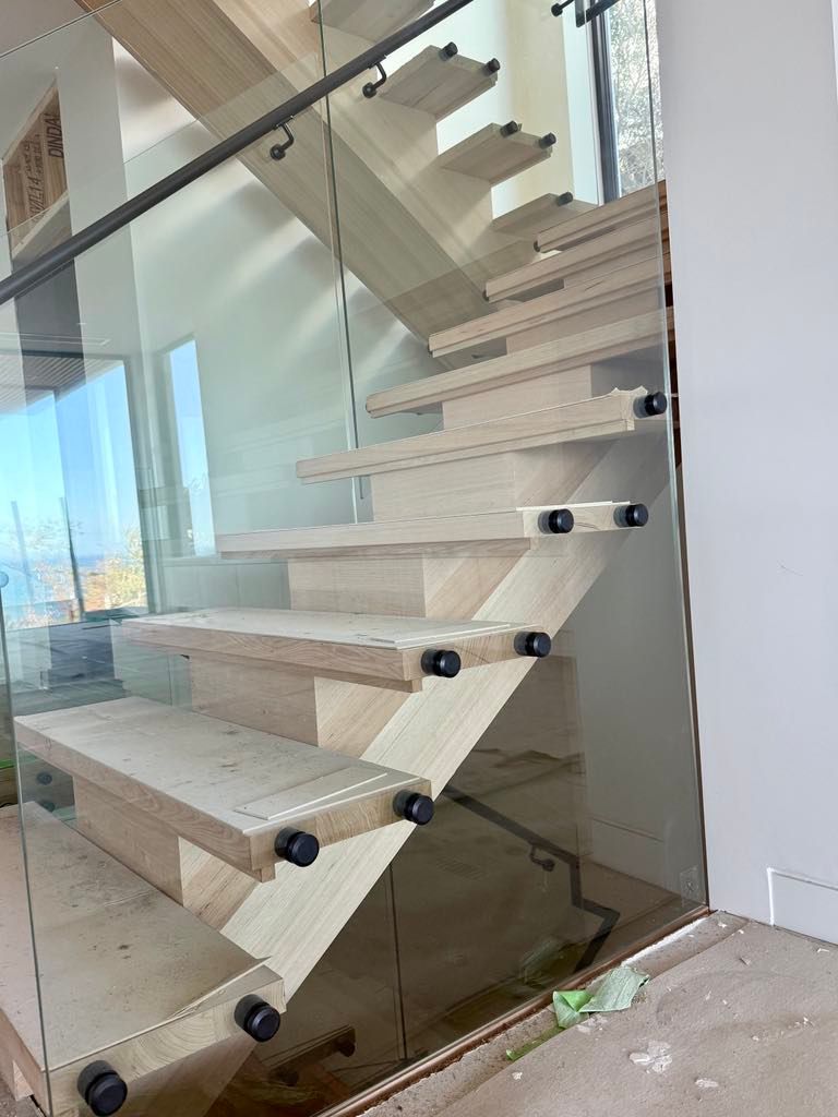 A Modern Staircase with Light Wood Treads and A Glass Railing — Coastline Glass Pool Fencing in Old Bar, NSW