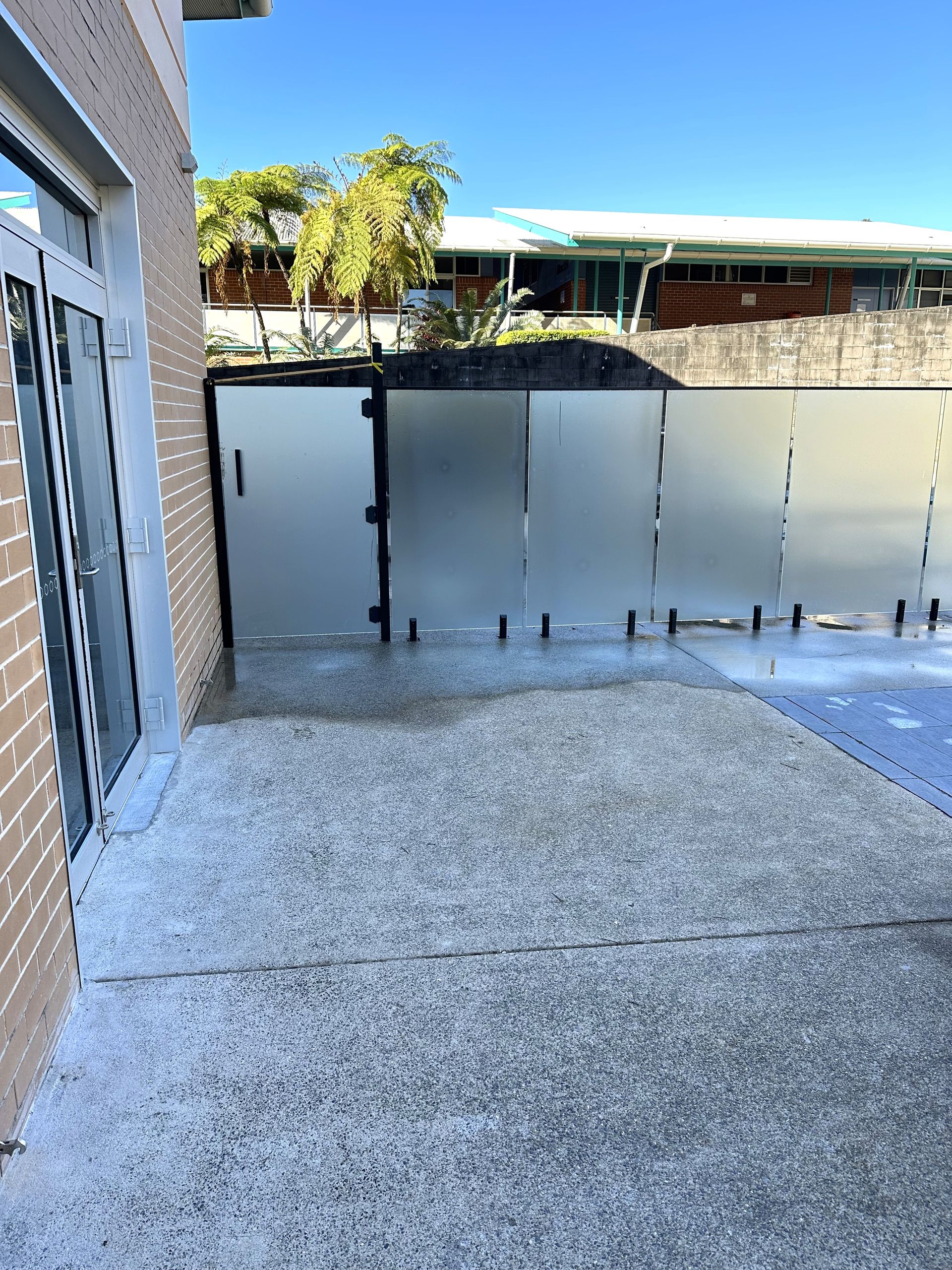 A Glass Door with A Staircase in The Background — Glass Pool Fencing Australia in Old Bar, NSW