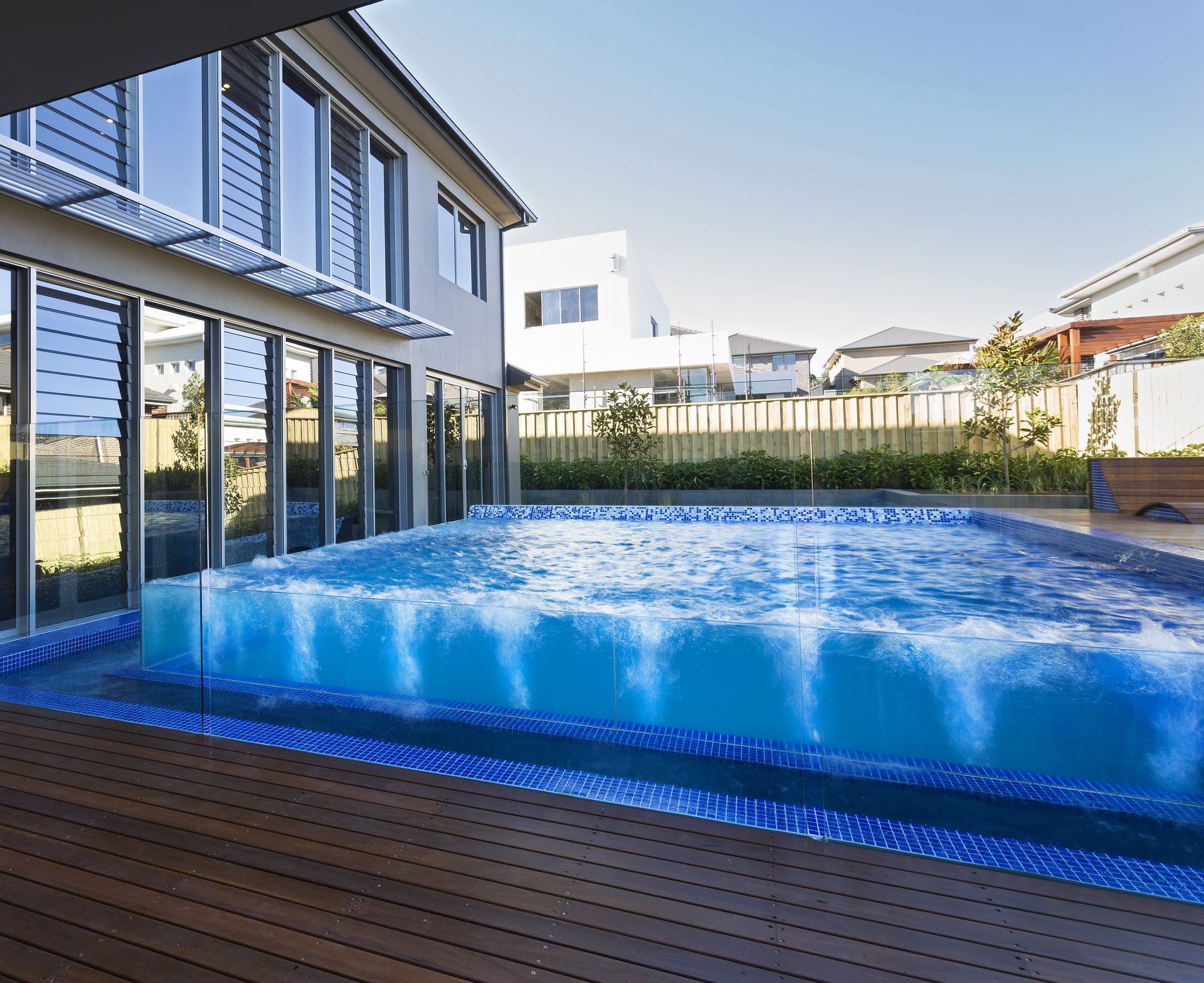 A large swimming pool in front of a house — Glass Pool Fencing Australia in Old Bar, NSW