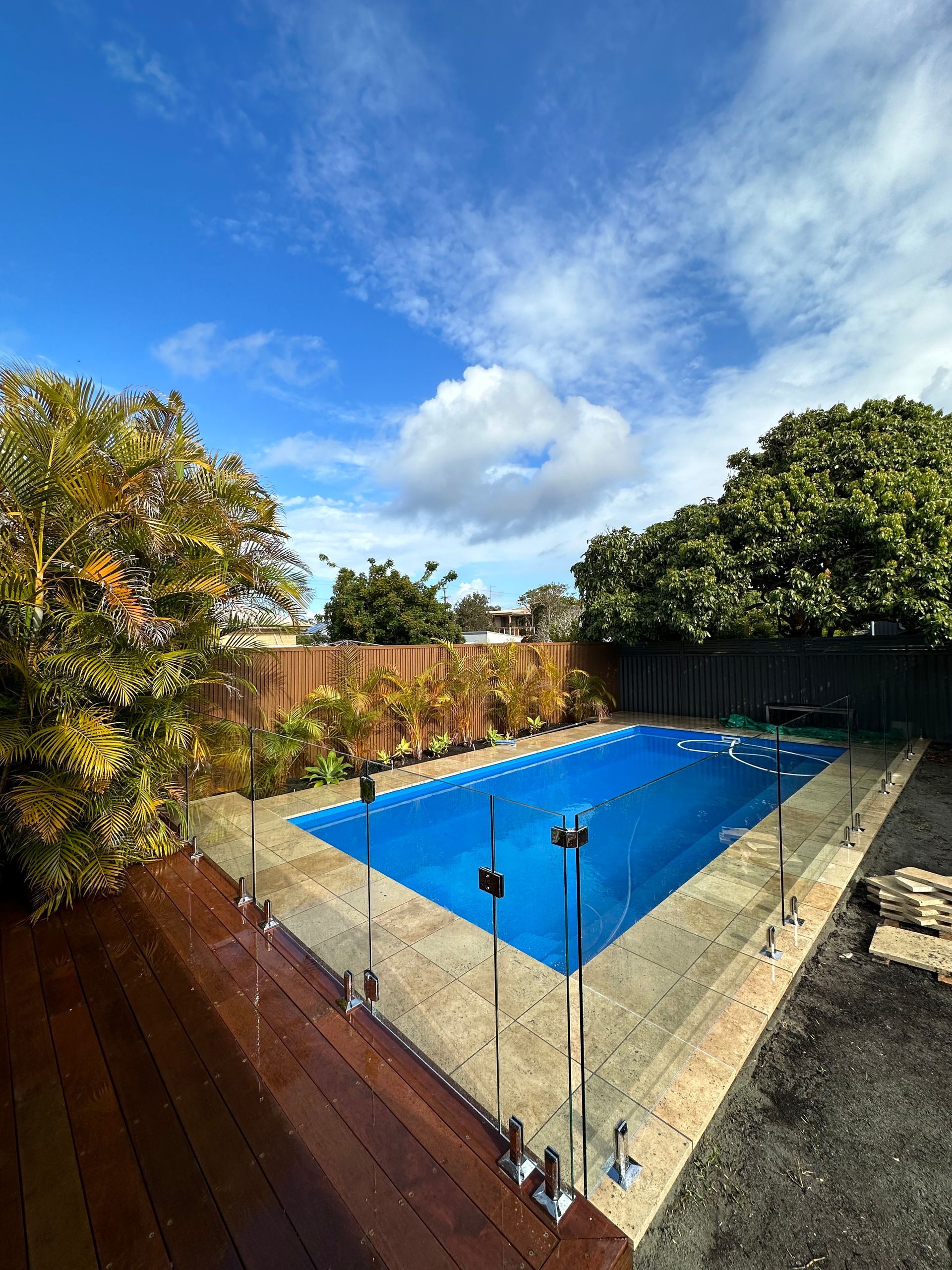 A Bright Blue Rectangular Swimming Pool with A Glass Fence — Coastline Glass Pool Fencing in Old Bar, NSW
