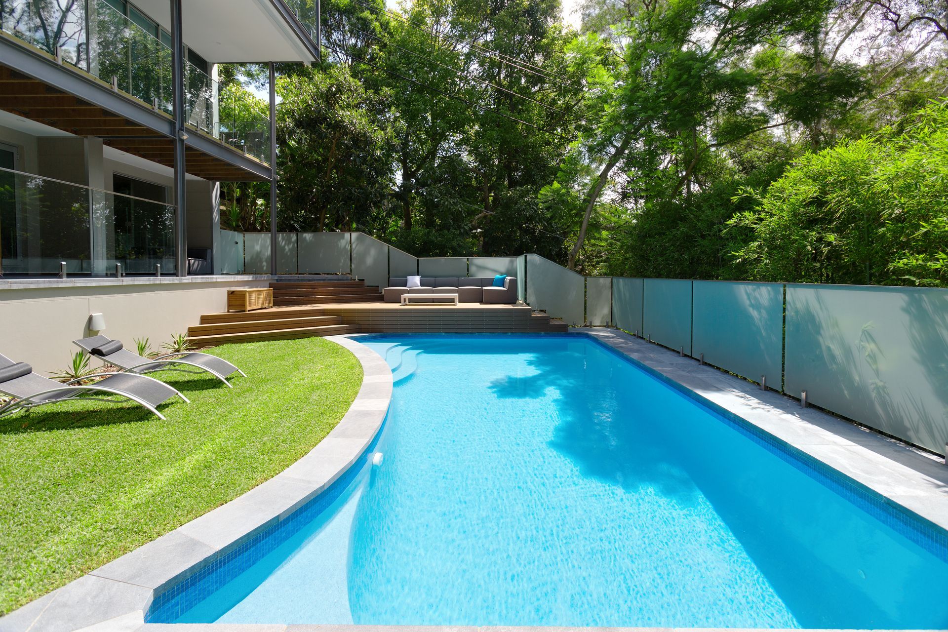 A large swimming pool in the backyard of a house — Glass Pool Fencing Australia in Old Bar, NSW