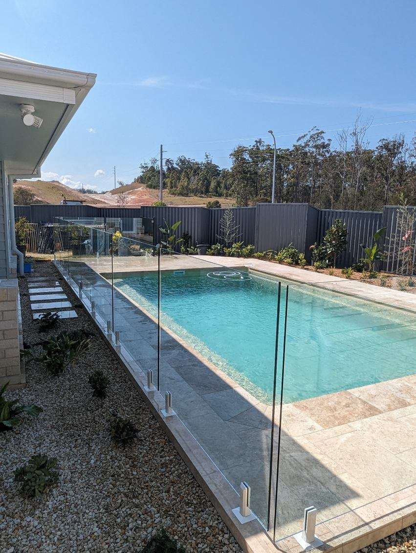 There is a large swimming pool in the backyard of a house. — Glass Pool Fencing Australia in Old Bar, NSW