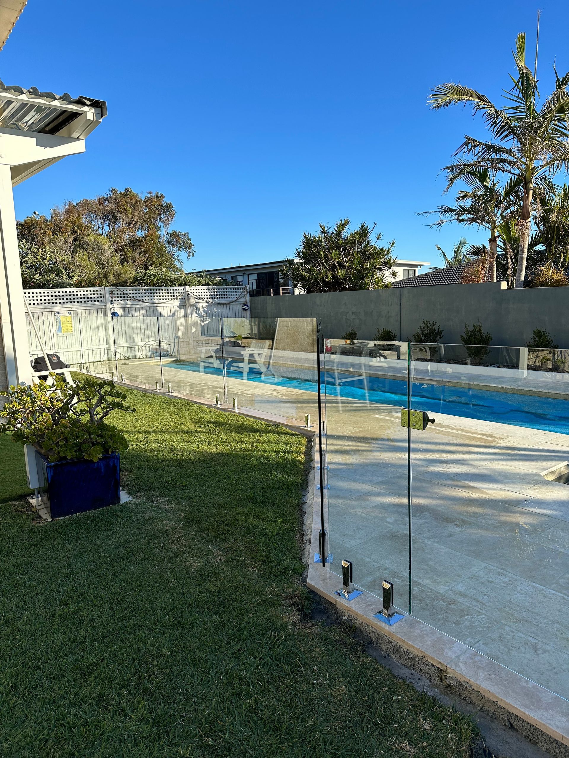 There is a swimming pool in the backyard of a house. — Glass Pool Fencing Australia in Old Bar, NSW