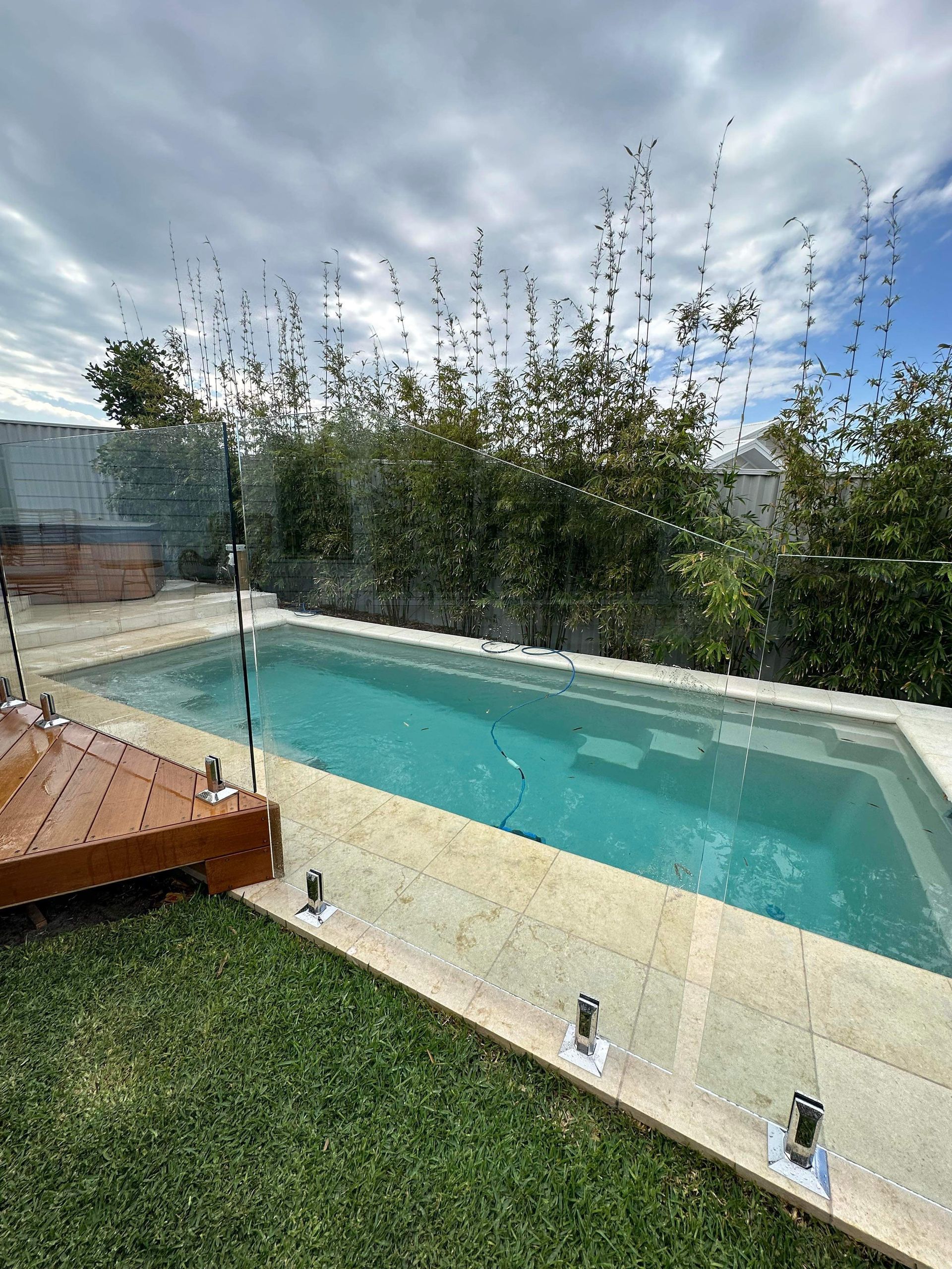 There Is a Large Swimming Pool in The Backyard of A House — Glass Pool Fencing Australia in Port Macquarie, NSW