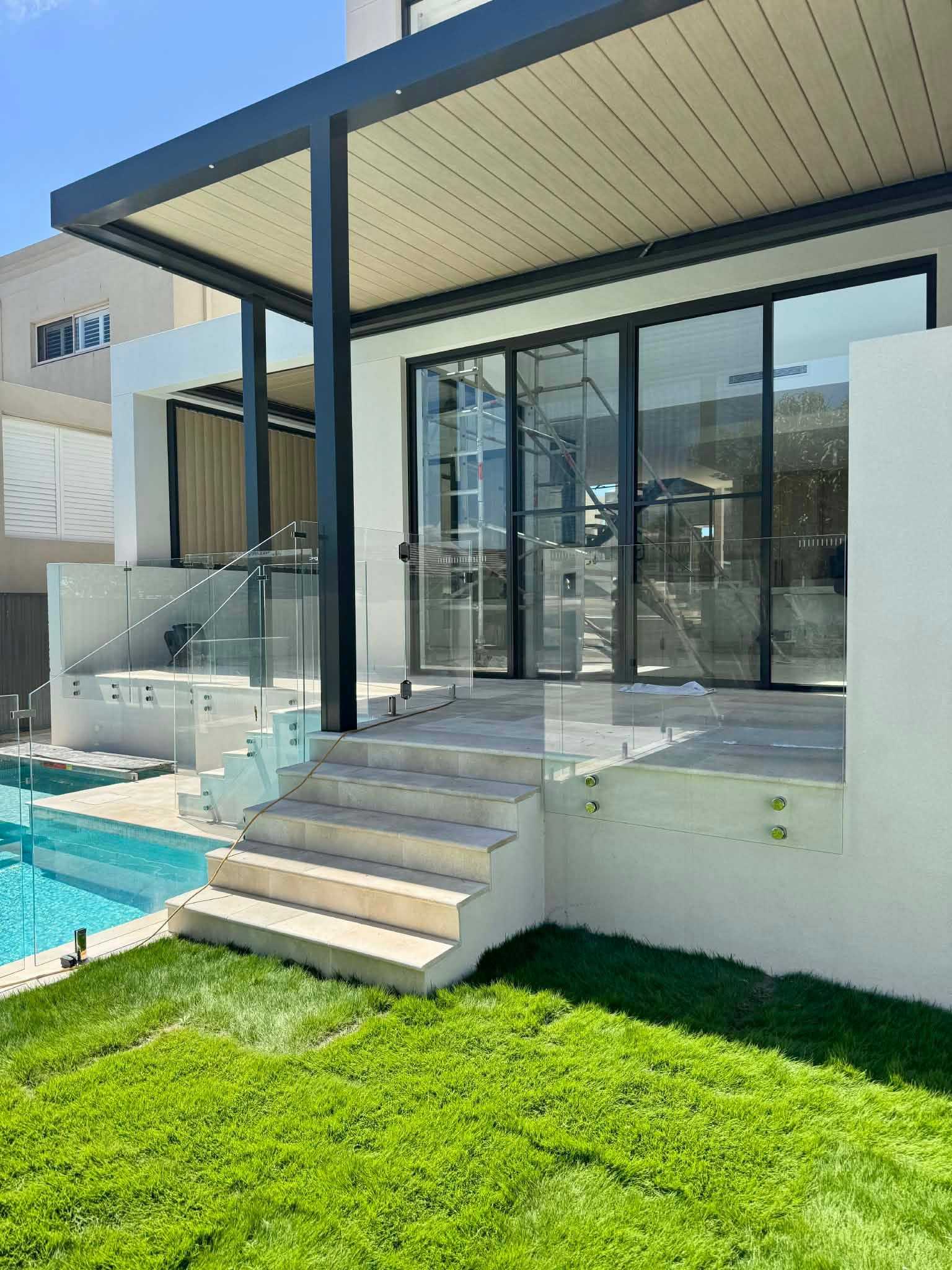 A Modern Patio with Beige Steps — Coastline Glass Pool Fencing in Old Bar, NSW