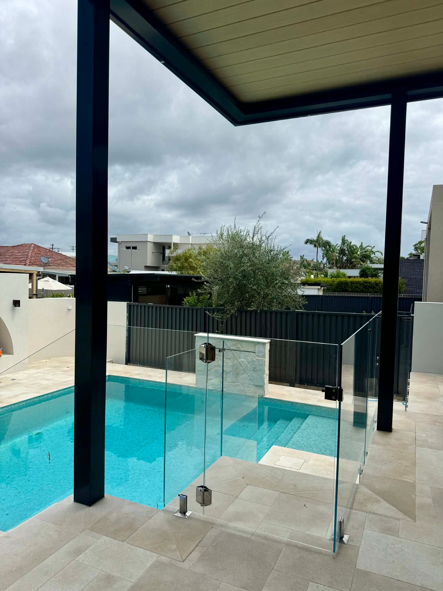 A Clear Glass Pool Fence with Metal Latches — Coastline Glass Pool Fencing in Old Bar, NSW
