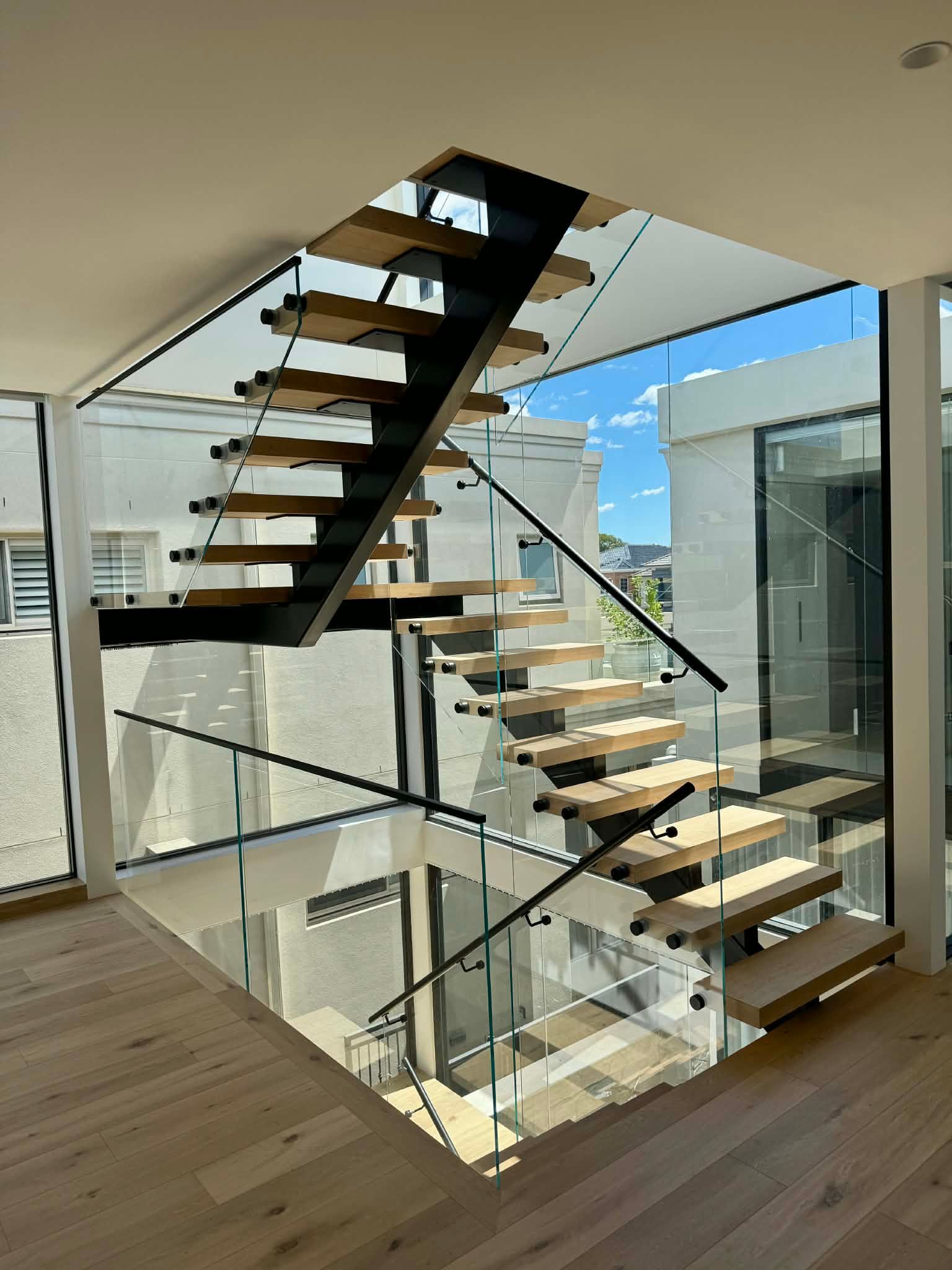A Modern, Floating Staircase with Light Wood Treads — Coastline Glass Pool Fencing in Old Bar, NSW