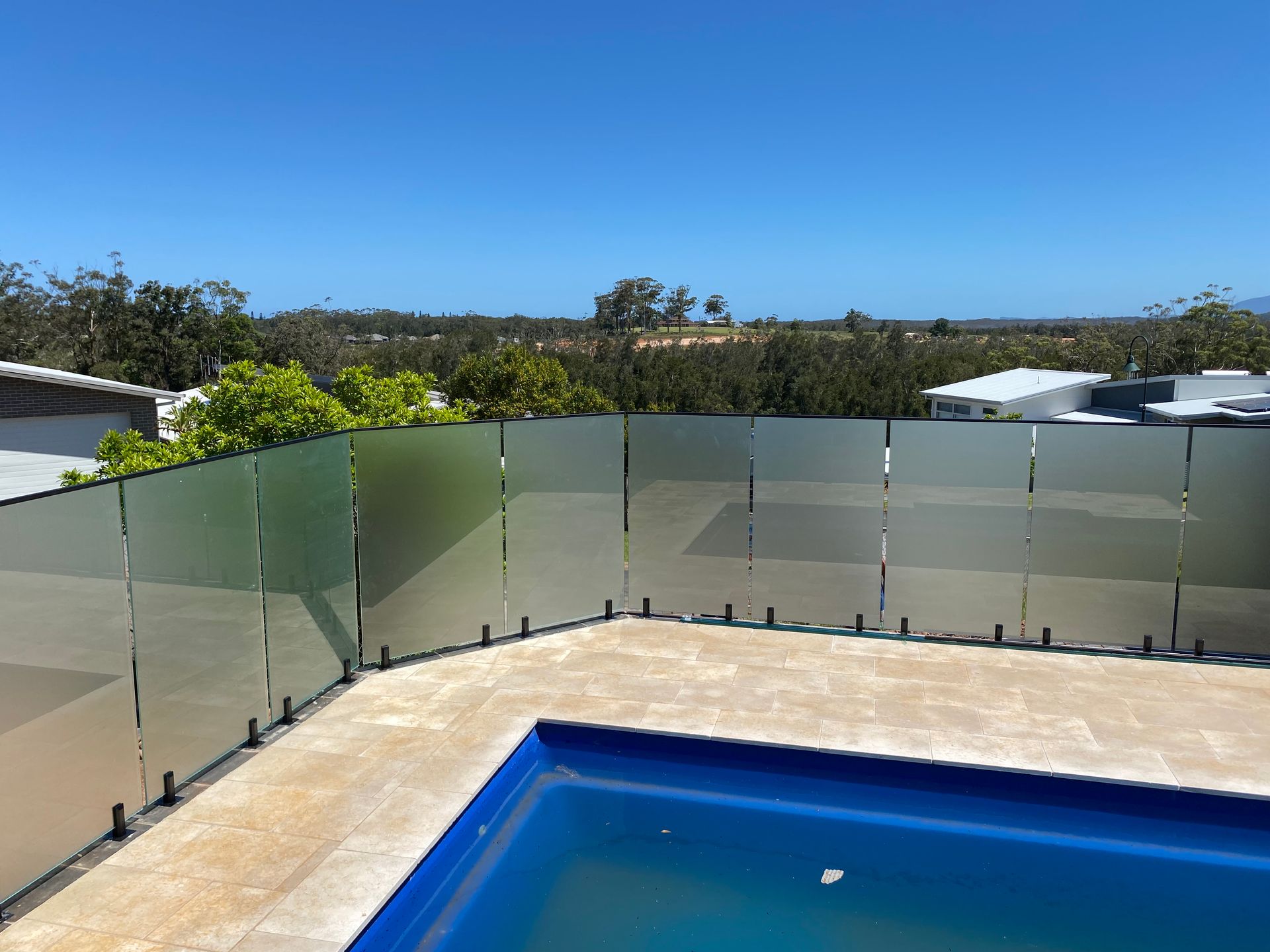A swimming pool with a glass fence around it — Glass Pool Fencing Australia in Old Bar, NSW