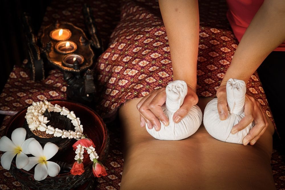 A Person is Getting a Massage With Two Bags of Herbal Balls — Siam Thai Massage In Tweed Heads, NSW