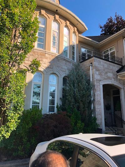 Man in blue gloves, installing a light fixture in a modern kitchen.