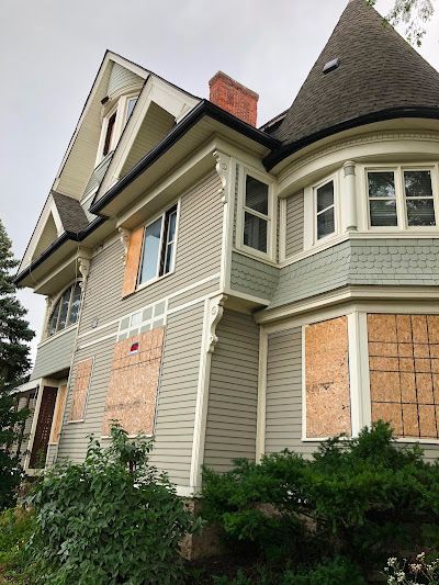 Man in blue gloves, installing a light fixture in a modern kitchen.
