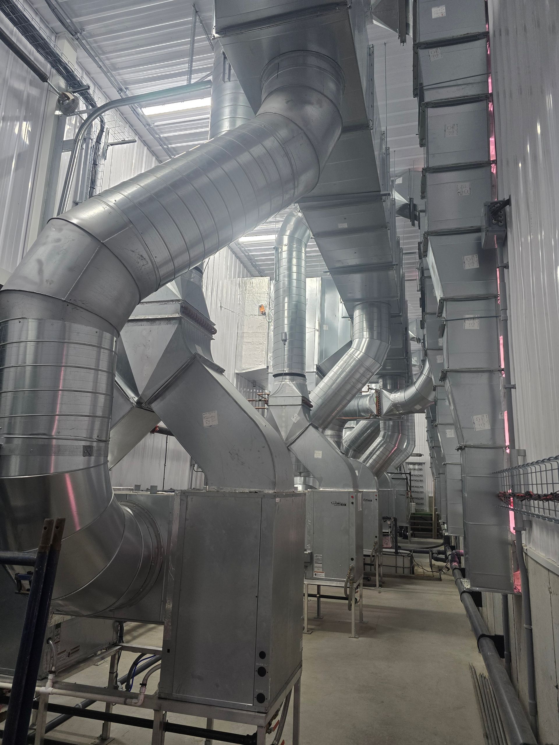 Une grande pièce avec beaucoup de tuyaux qui la traversent.