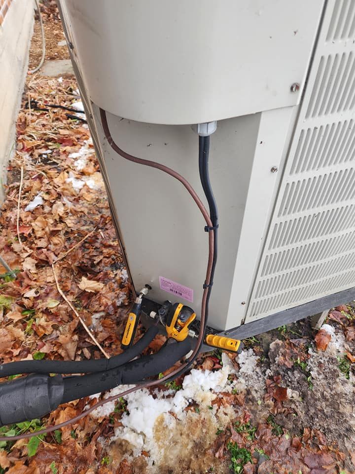 Un gros plan d'un climatiseur avec un tuyau attaché dessus.