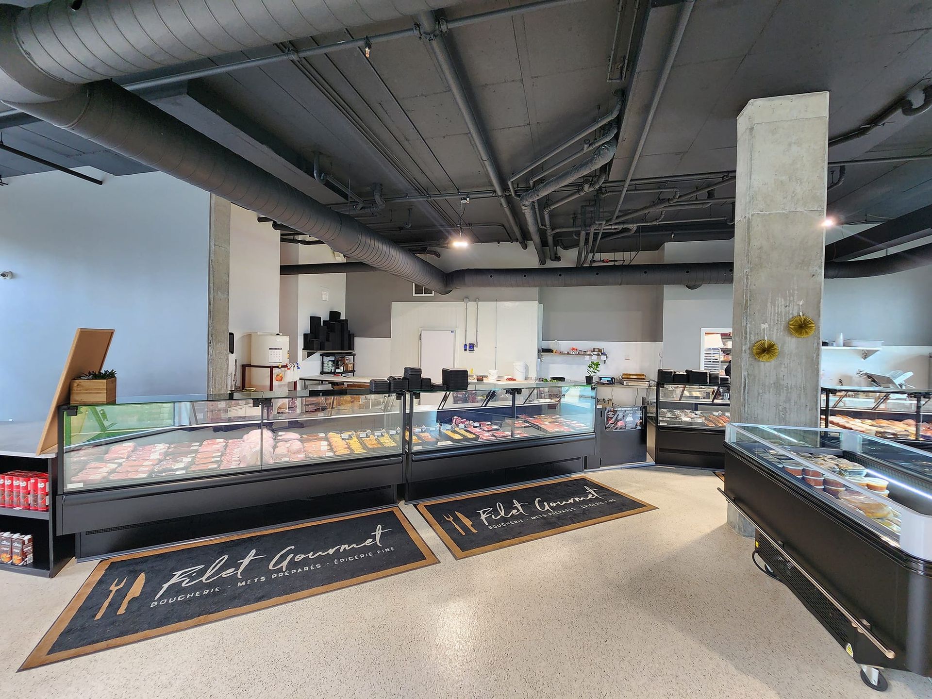 Une boucherie avec beaucoup de vitrines remplies de viande.